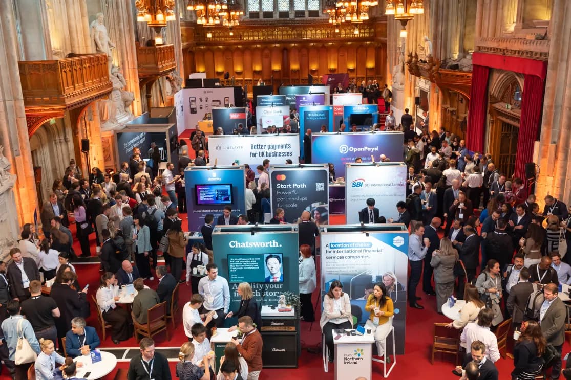Attendees networking near sponsorship booth at the forum